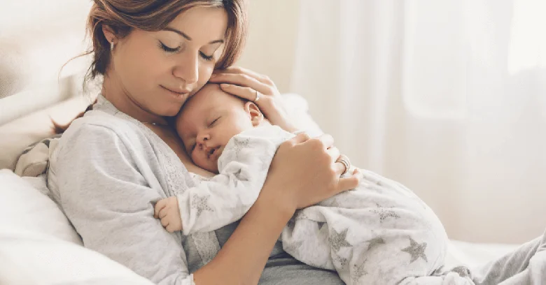 A mother holding her baby closely