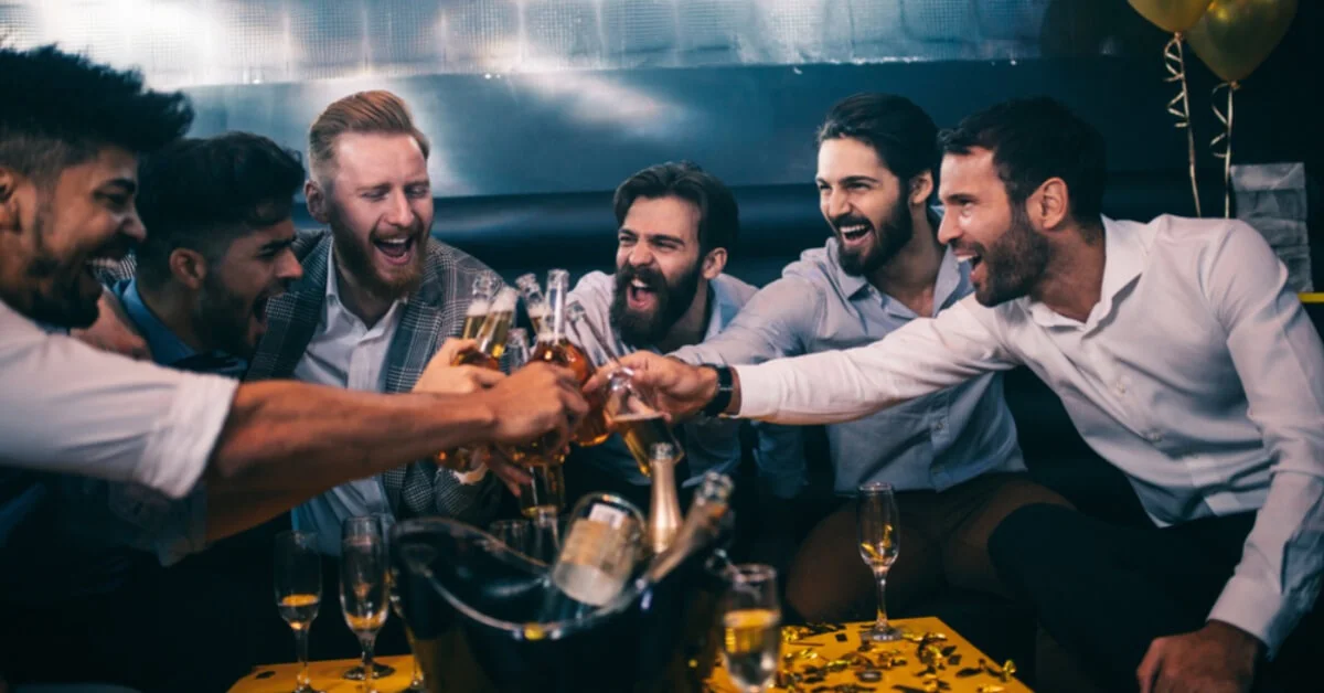 young men toasting beer in a nightclub
