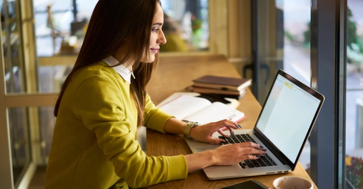 a young woman smiling on her laptop