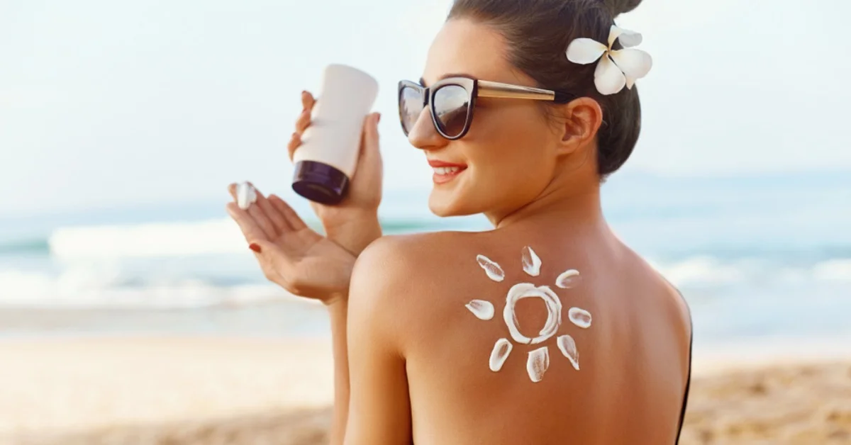a woman smiling on a beach with suncream