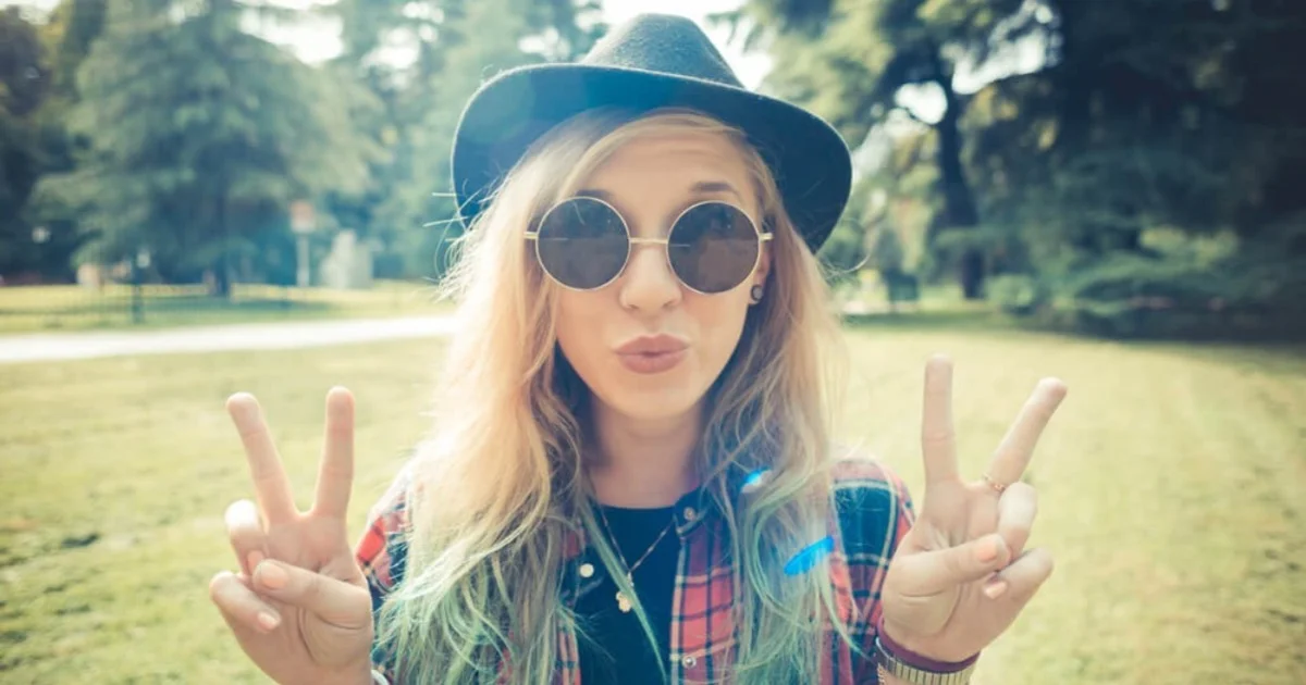 a young woman wearing a funky hat and sunglasses