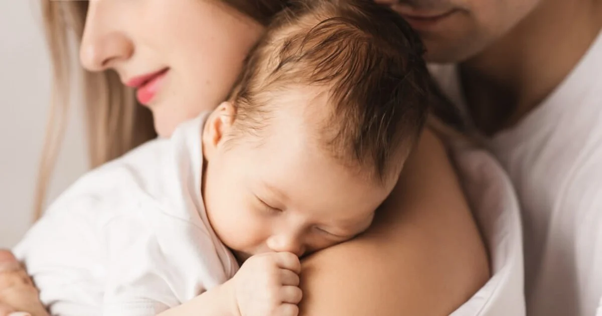 a baby being held lovingly by its mum and dad